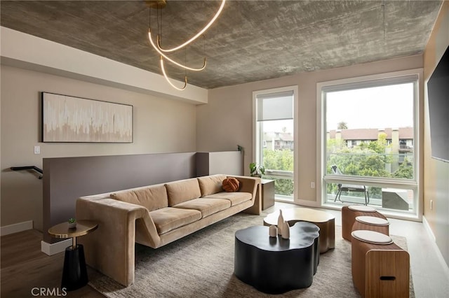 living room featuring dark hardwood / wood-style floors, a wealth of natural light, and an inviting chandelier