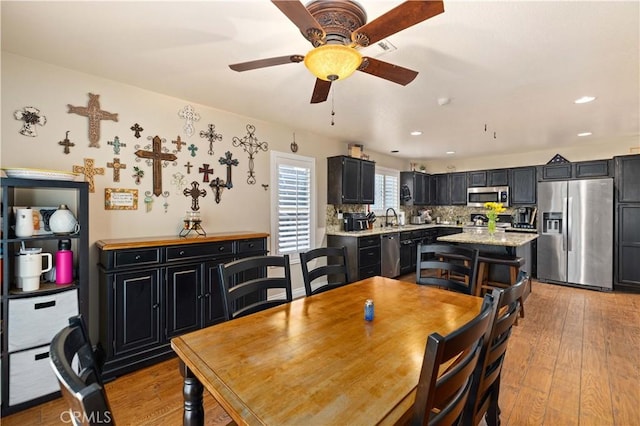 dining room with ceiling fan, light wood-type flooring, and sink