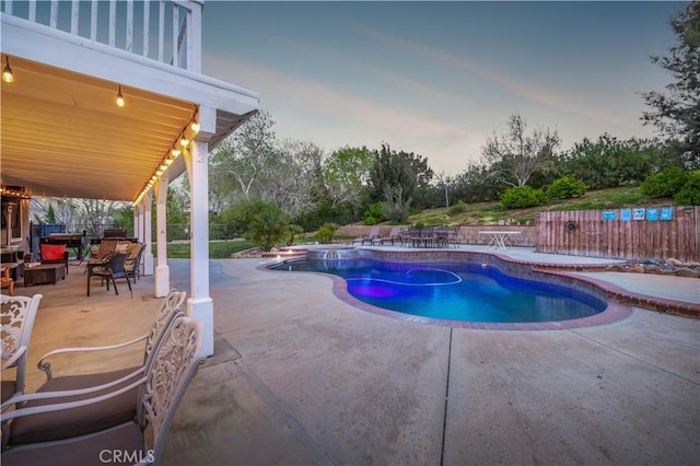 pool at dusk with a patio area