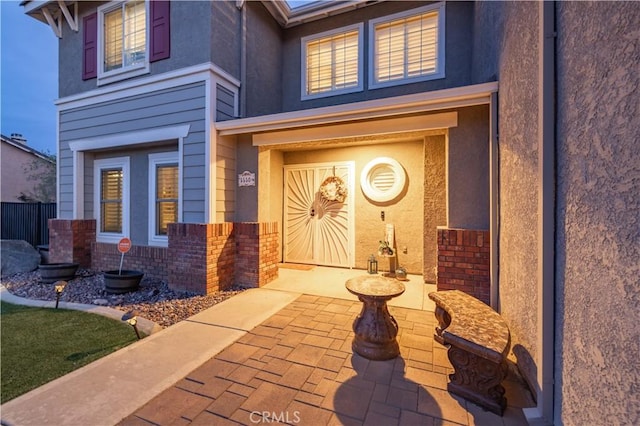 view of exterior entry with a patio