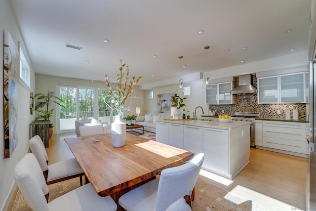 dining space with light wood-type flooring and sink