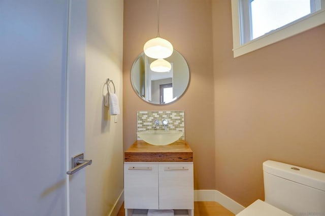 bathroom with vanity, toilet, and tasteful backsplash