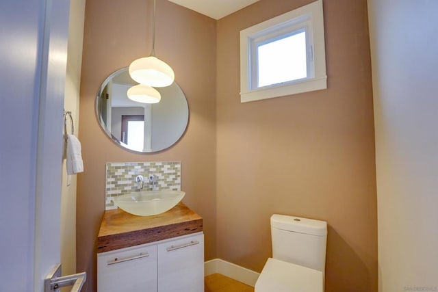 bathroom with tasteful backsplash, vanity, and toilet