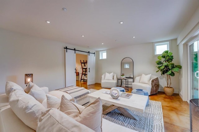 living room with light hardwood / wood-style floors, a barn door, and a healthy amount of sunlight