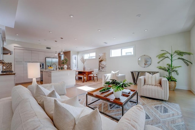 living room featuring light wood-type flooring and sink