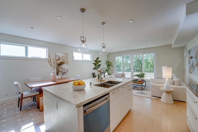 kitchen with a kitchen island with sink, sink, decorative light fixtures, dishwasher, and white cabinets