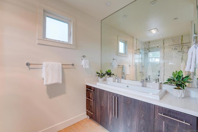 bathroom with hardwood / wood-style flooring, vanity, and walk in shower