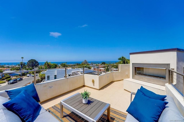 view of patio with an outdoor fireplace and a balcony