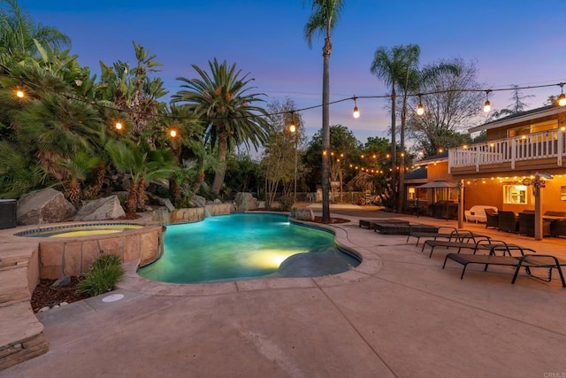 pool at dusk featuring a patio area, an in ground hot tub, and an outdoor living space