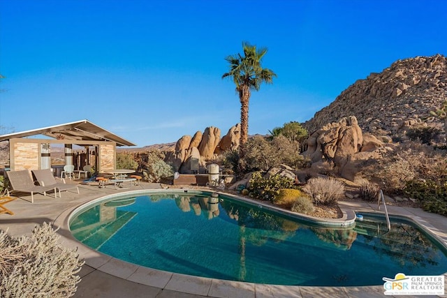 view of swimming pool featuring a mountain view and a patio