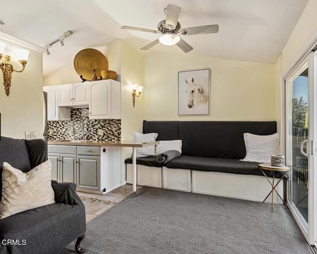 sitting room with sink, light tile patterned floors, track lighting, and lofted ceiling