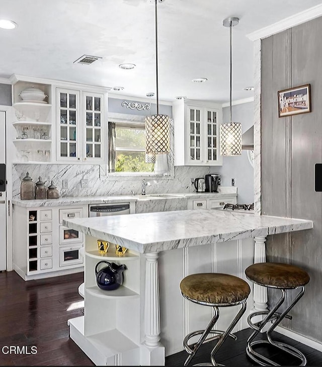 kitchen featuring white cabinets, hanging light fixtures, and a breakfast bar area