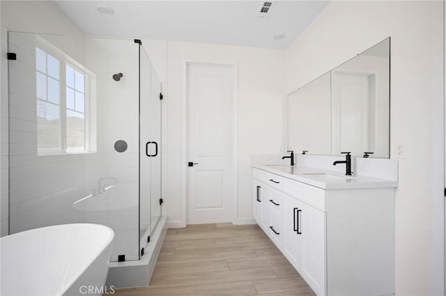 bathroom featuring vanity, wood-type flooring, and independent shower and bath