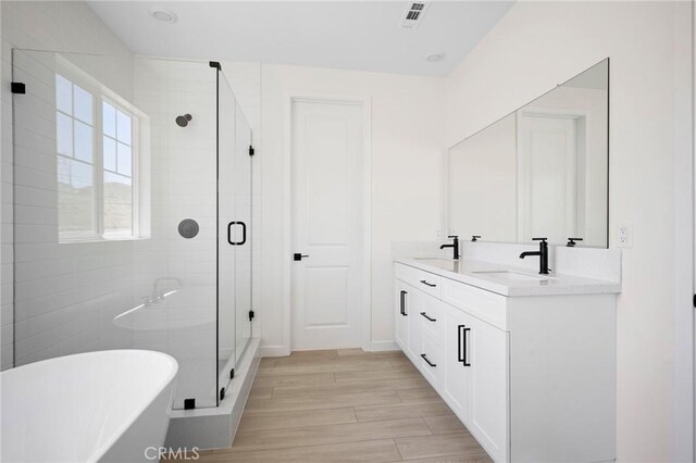 23724 Wilcox Dr, Newhall, CA 91321 - full bathroom featuring a freestanding bath, a shower stall, double vanity, and wood finished floors
