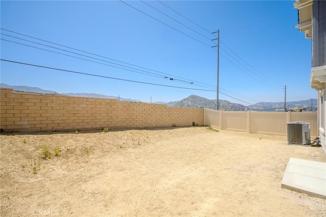 view of yard with central AC unit and a mountain view