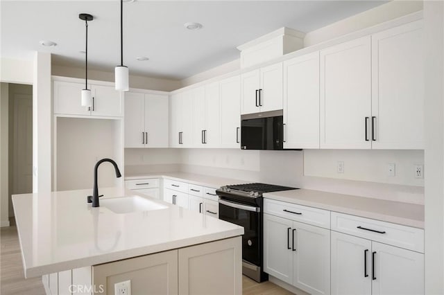 23724 Wilcox Dr, Newhall, CA 91321 - kitchen featuring gas stove, an island with sink, white cabinetry, and light wood-style floors