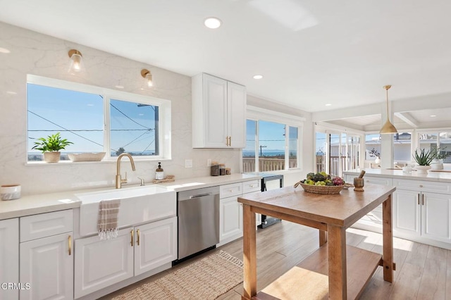 kitchen with recessed lighting, white cabinetry, light countertops, dishwasher, and light wood finished floors