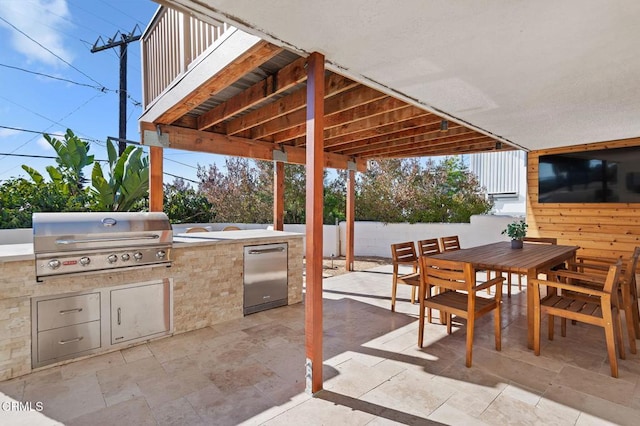 view of patio / terrace featuring fence, an outdoor kitchen, area for grilling, and outdoor dining space