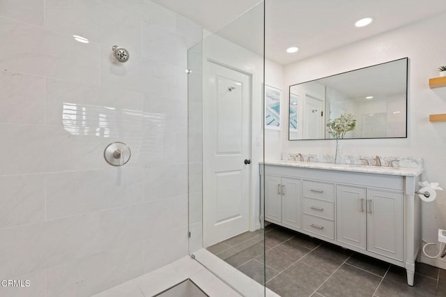 full bath featuring tile patterned flooring, a walk in shower, a sink, and double vanity