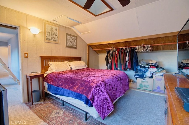 carpeted bedroom with ceiling fan, wood walls, and lofted ceiling