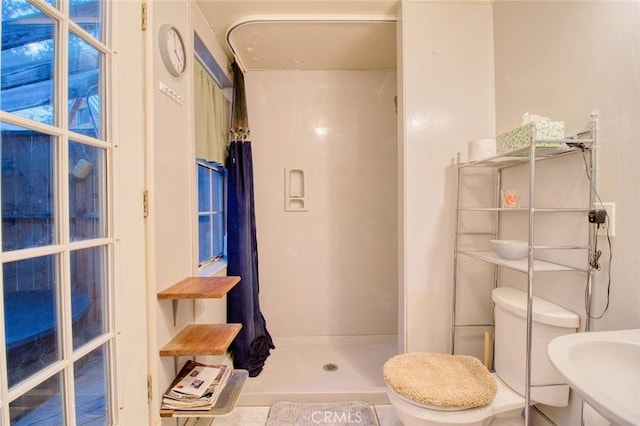 bathroom with sink, tile patterned flooring, toilet, and walk in shower