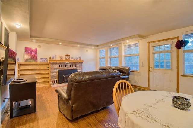 living room featuring hardwood / wood-style flooring, a fireplace, and a tray ceiling