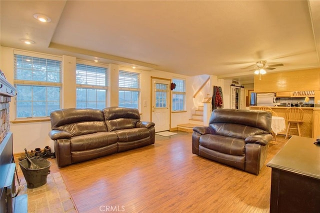 living room featuring light wood-type flooring and ceiling fan