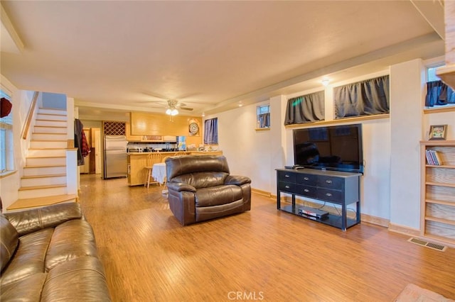 living room featuring light hardwood / wood-style floors and ceiling fan