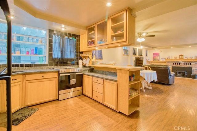 kitchen with kitchen peninsula, light brown cabinetry, stainless steel range with electric stovetop, ceiling fan, and light hardwood / wood-style floors