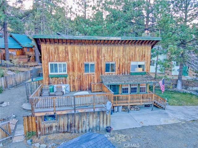 view of front of house featuring a wooden deck and a patio