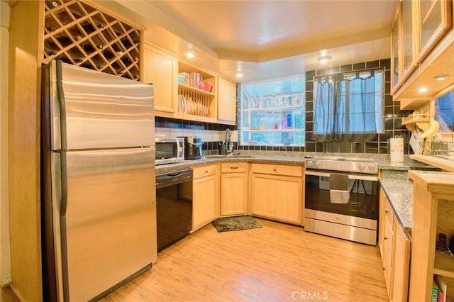 kitchen with sink, decorative backsplash, light brown cabinetry, appliances with stainless steel finishes, and light wood-type flooring