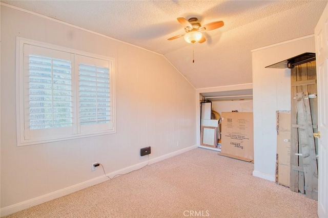 carpeted spare room with ceiling fan, a textured ceiling, and vaulted ceiling