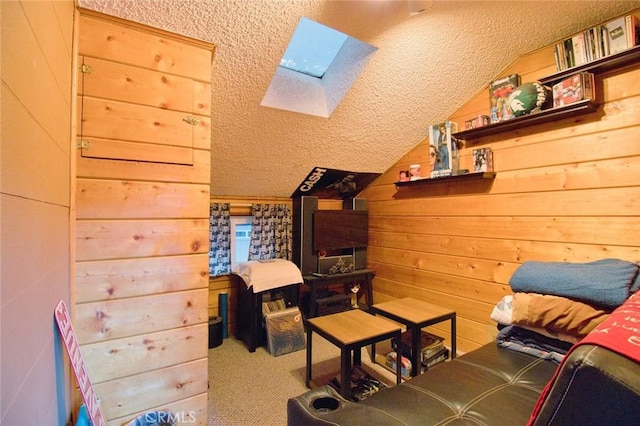 living area with vaulted ceiling with skylight, carpet flooring, wood walls, and a textured ceiling