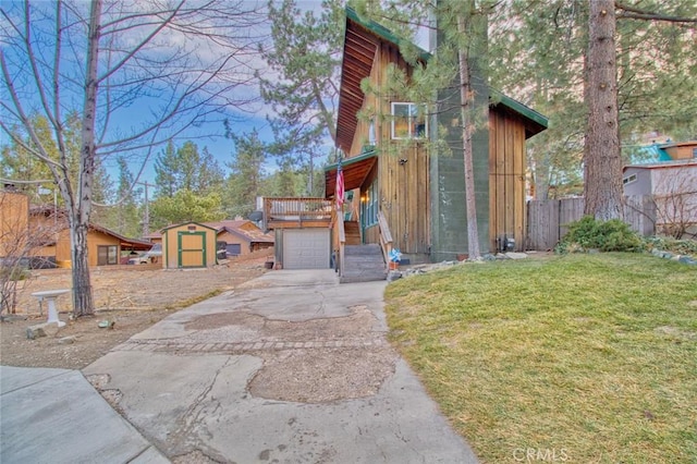 exterior space featuring a garage, a shed, a deck, and a yard