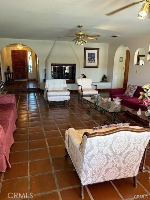 tiled living room featuring ceiling fan and vaulted ceiling