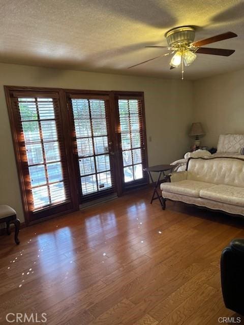 unfurnished bedroom with ceiling fan, wood-type flooring, a textured ceiling, and access to outside