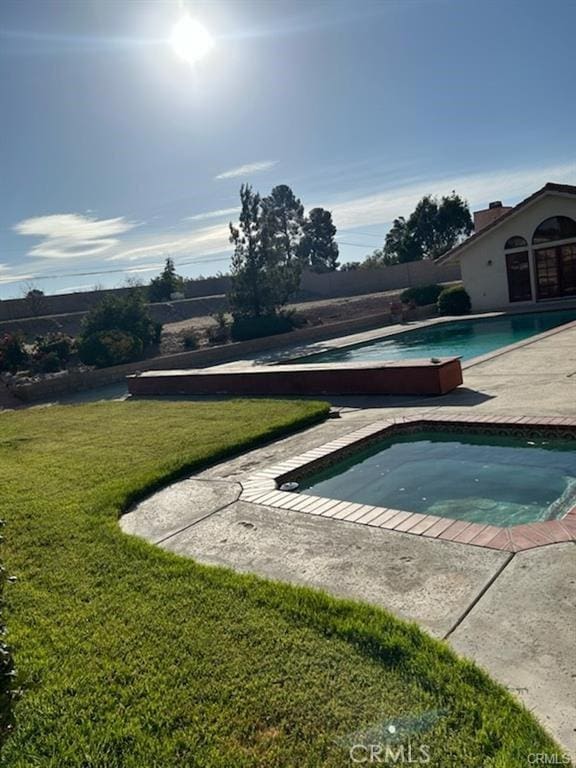 view of pool with a patio and a lawn