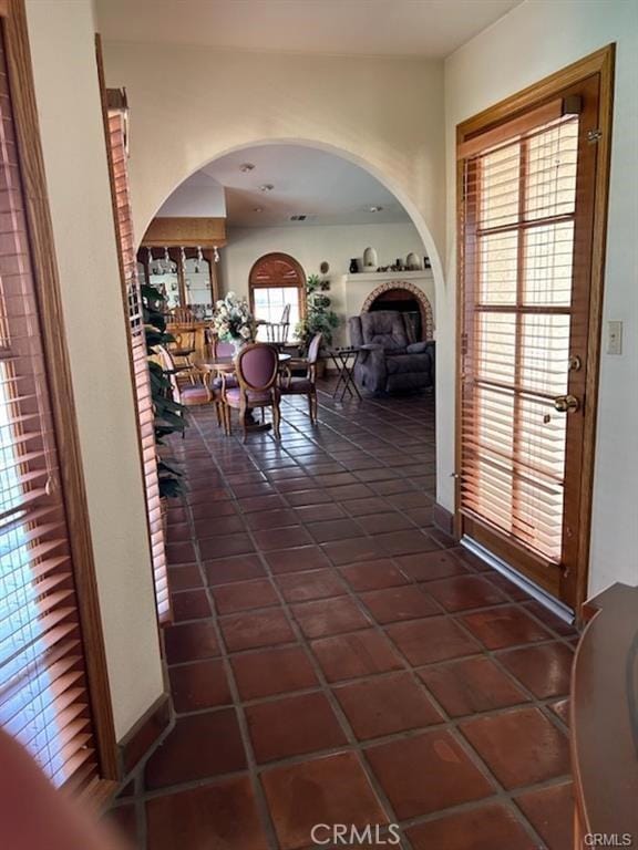 corridor with dark tile patterned flooring and a wealth of natural light