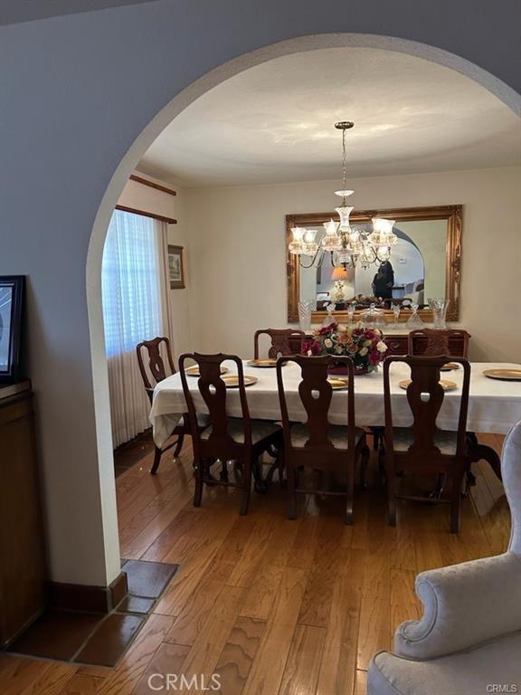 dining area featuring wood-type flooring and a notable chandelier