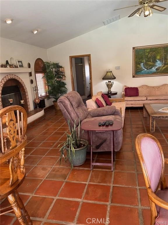 tiled living room with ceiling fan and lofted ceiling