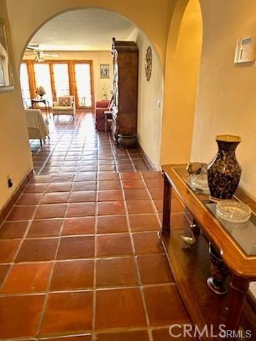 hall featuring dark tile patterned flooring