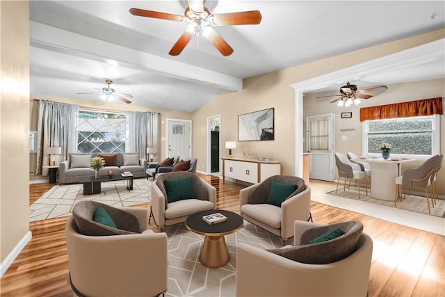 living room with lofted ceiling with beams and light hardwood / wood-style flooring