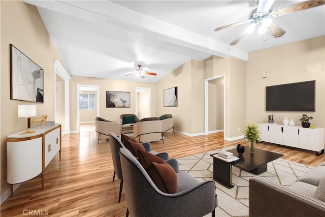 living room with beam ceiling, ceiling fan, and light wood-type flooring