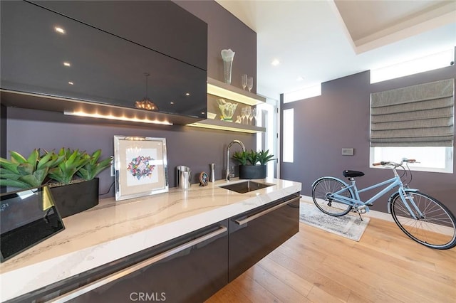 kitchen featuring light hardwood / wood-style floors, light stone counters, and sink