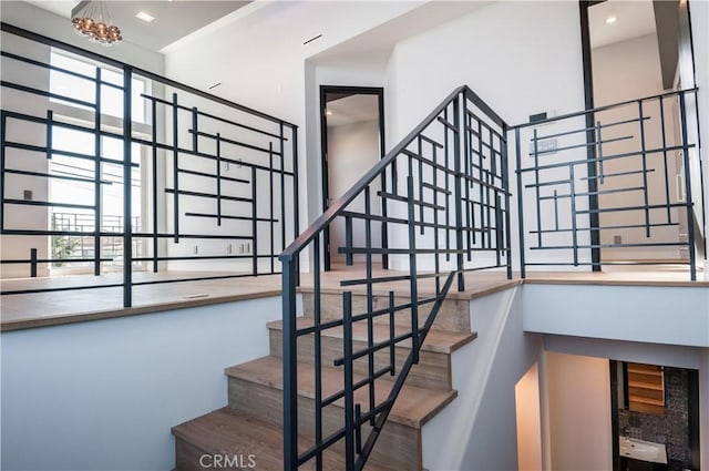 staircase with a chandelier and a healthy amount of sunlight