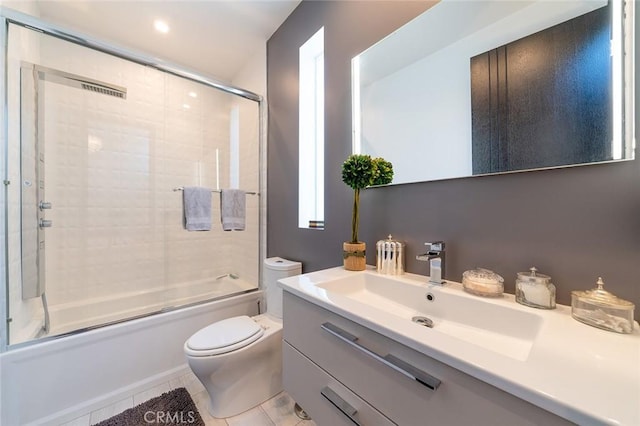 full bathroom with shower / bath combination with glass door, vanity, tile patterned floors, and toilet