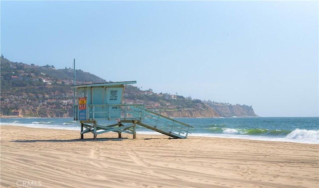 exterior space featuring a water view and a beach view