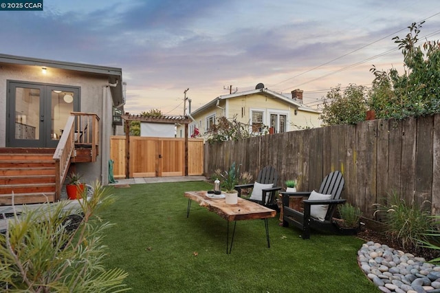 yard at dusk featuring french doors