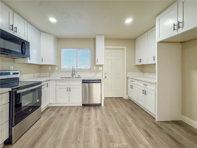 kitchen featuring light hardwood / wood-style floors, white cabinetry, sink, and appliances with stainless steel finishes