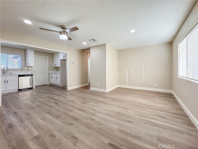 unfurnished living room with ceiling fan, sink, and light hardwood / wood-style floors